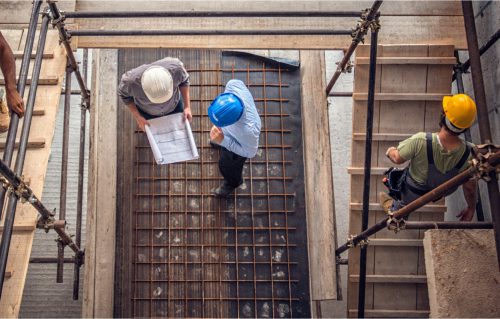 an over head view of work men discussing plans on a building site